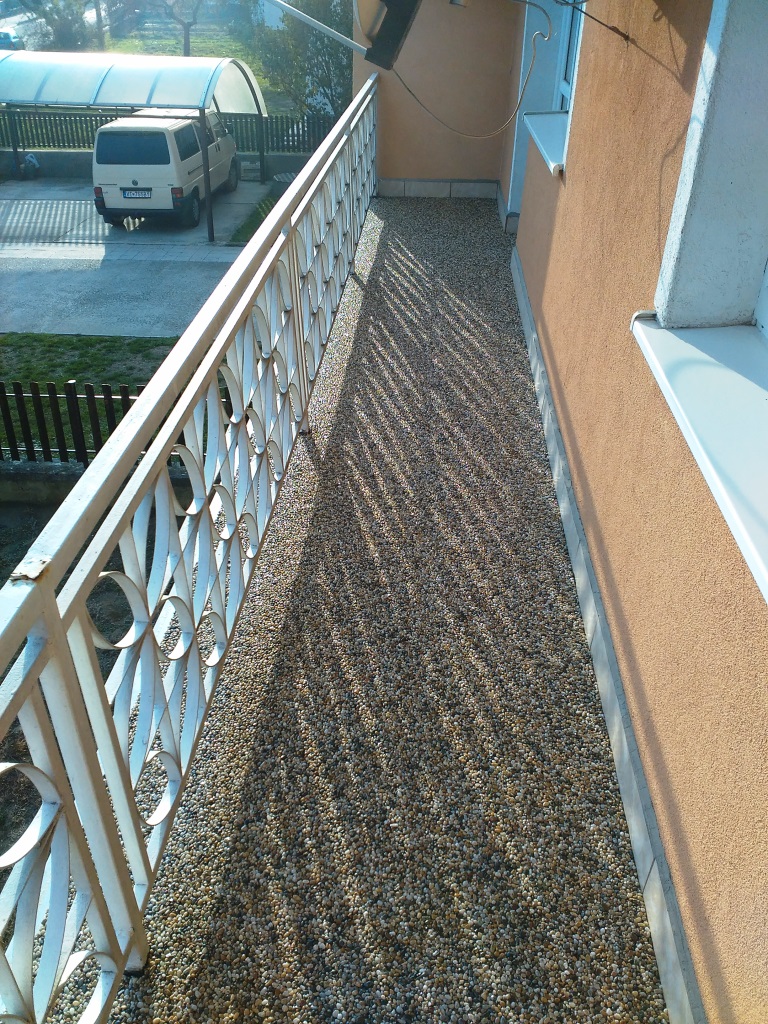 Kamenný koberec na balkóne domu
