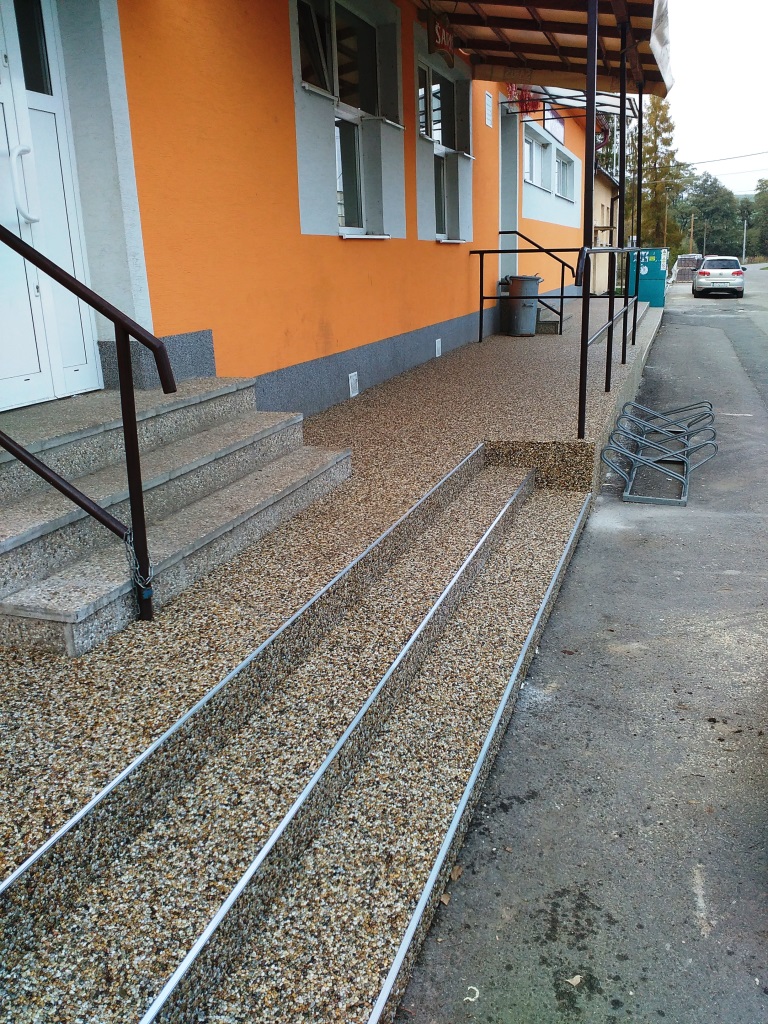 Kamenný koberec na schodoch a terase pred budovou firmy